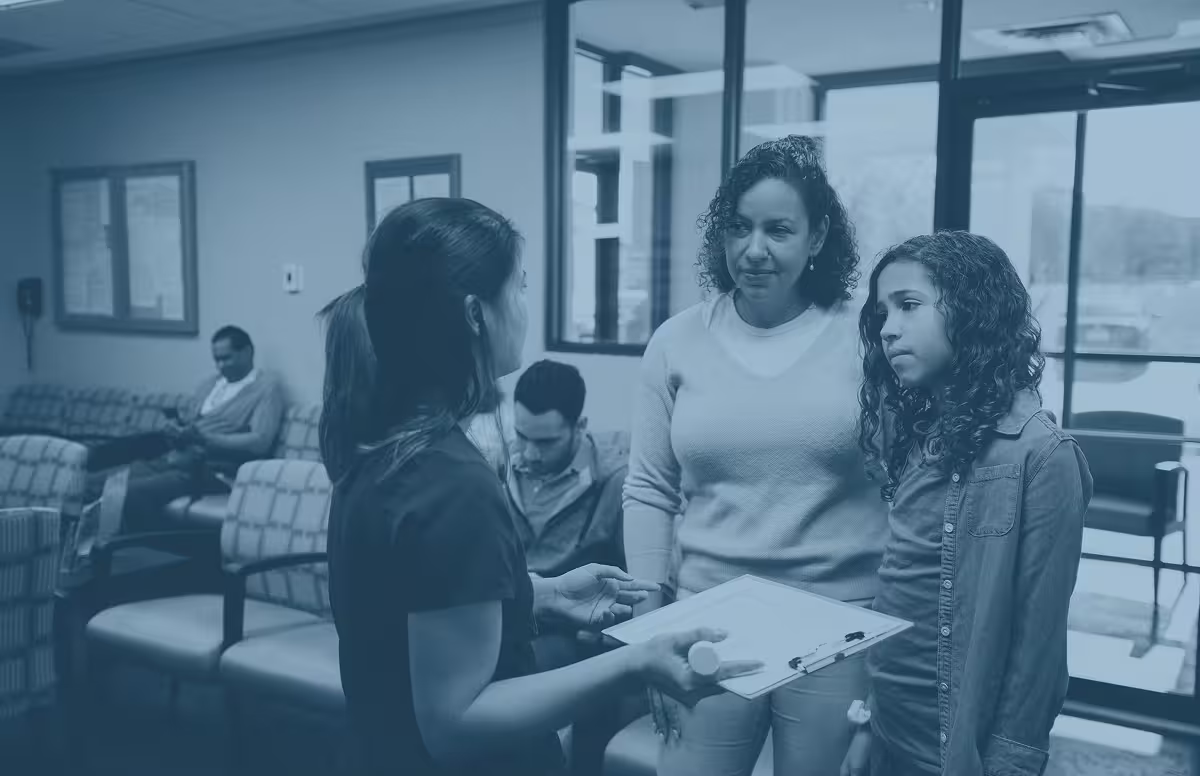 Provider speaking with a mother and child in a clinic