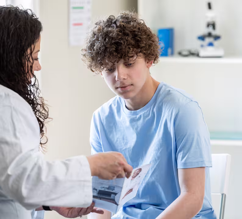 Healthcare provider discussing information with a teenage boy
